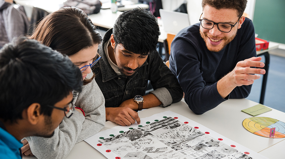 Studierende sitzen bei der Lehrveranstaltung Serious Games an einem Tisch und spielen eines der entwickelten Spiele (c) Jana Dünnhaupt Uni Magdeburg