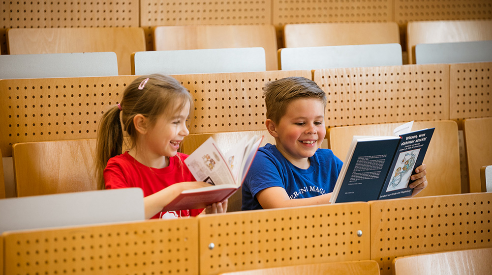 /unimagdeburg_media/Presse/Bilder/Pressemitteilungen/2023/Die+Kinder_Uni_Botschafter+Nora+und+Henri+sitzen+im+H%C3%B6rsaal+mit+B%C3%BCchern+in+der+Hand+%28c%29+Jana+D%C3%BCnnhaupt+Uni+Magdeburg-height-560-width-1000-p-108830.jpg