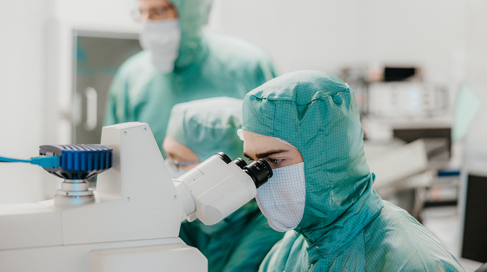 /unimagdeburg_media/Presse/Bilder/Pressemitteilungen/2024/Ein+Mikrotechnologie+Azubi+sitzt+mit+kompletten+Vollschutz+an+einem+Mikroskop+und+schaut+hinein+%28c%29+Hannah+Theile+Uni+Magdeburg-height-560-width-1000.jpg